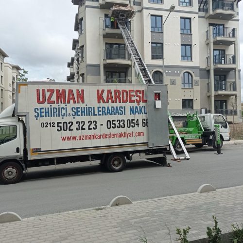 Asansörlü taşımacılık ekibi, eşyaları dikkatle naklediyor.