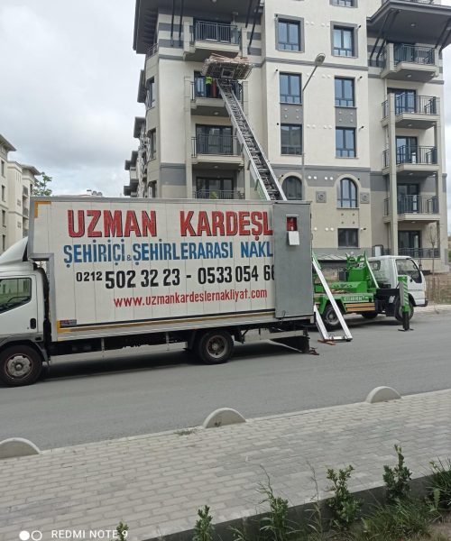 Asansörlü taşımacılık ekibi, eşyaları dikkatle naklediyor.