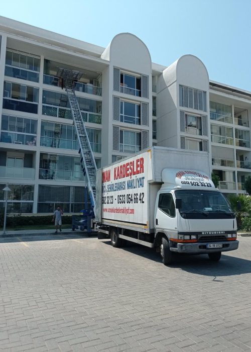 Asansörlü taşımacılık ekibi, eşyaları yüksek katlardan güvenle indiriyor.